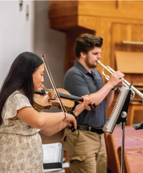 A man playing the trumpet and a woman playing the violin.